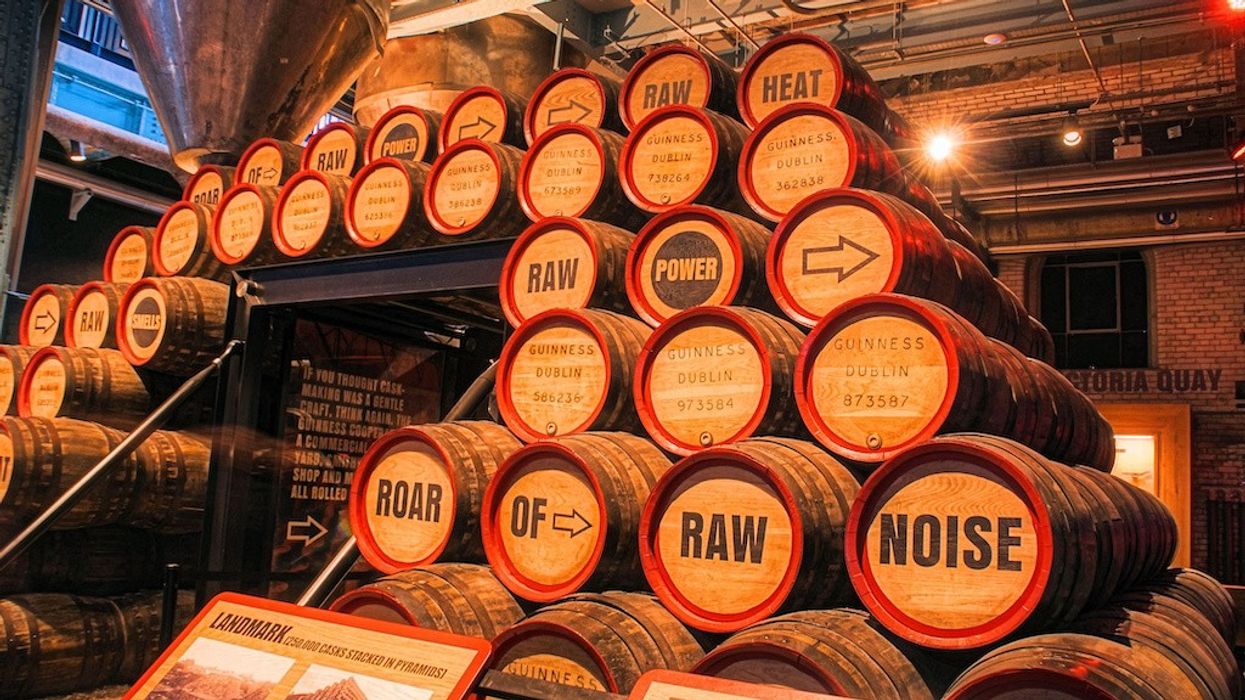 Stacked wooden barrels with text like "RAW NOISE" in a brewery exhibit.