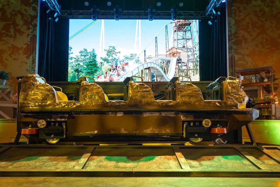 Stage display of a Rip Roarin' Falls ride vehicle with a backdrop of a coaster track.