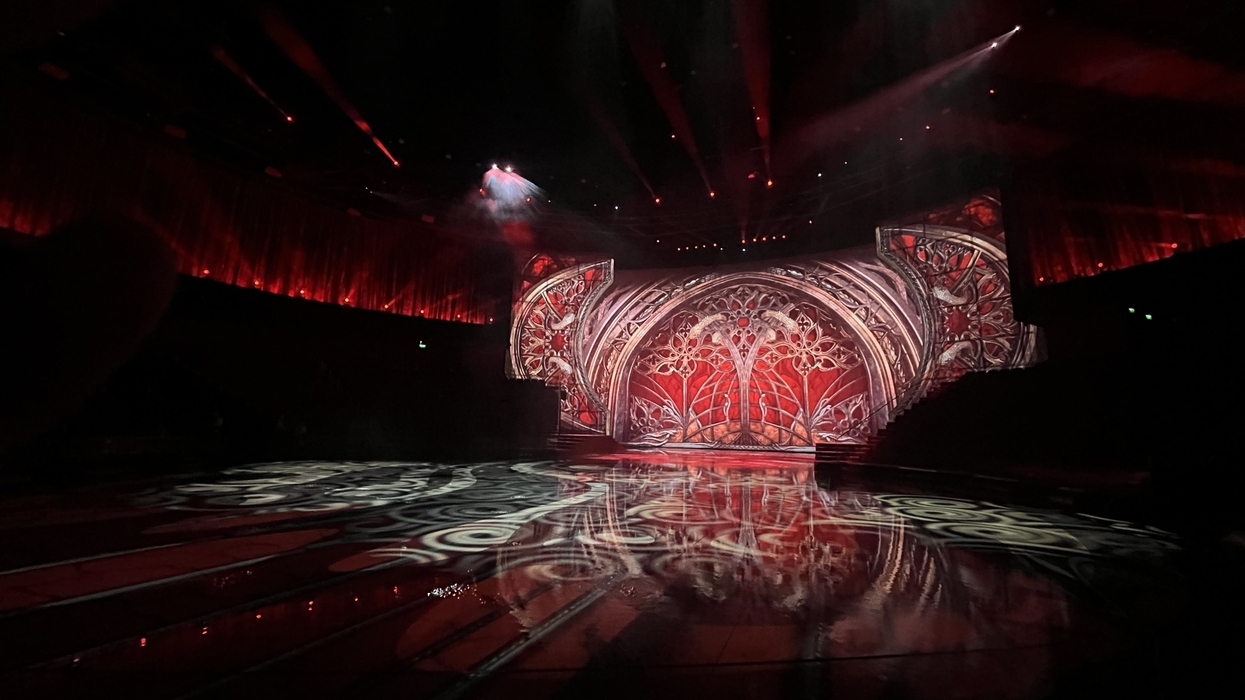 Stage with intricate red and white patterns under dramatic lighting.