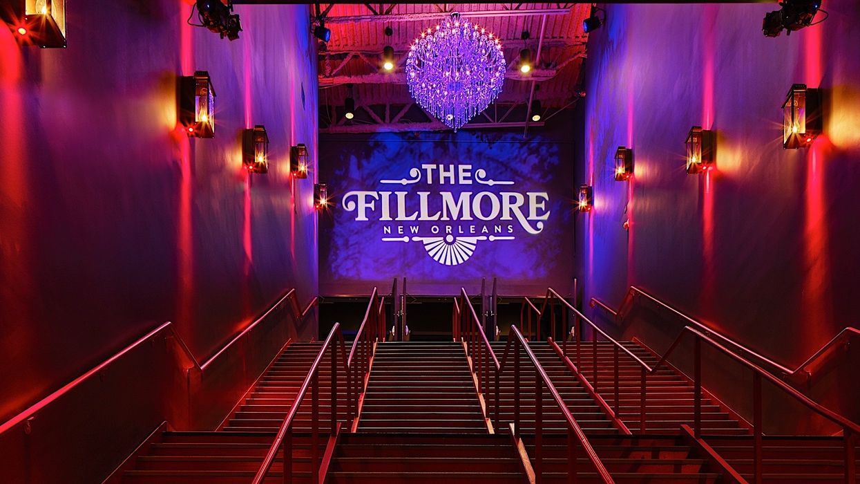 Staircase leading to The Fillmore New Orleans, lit by a chandelier and wall lights.