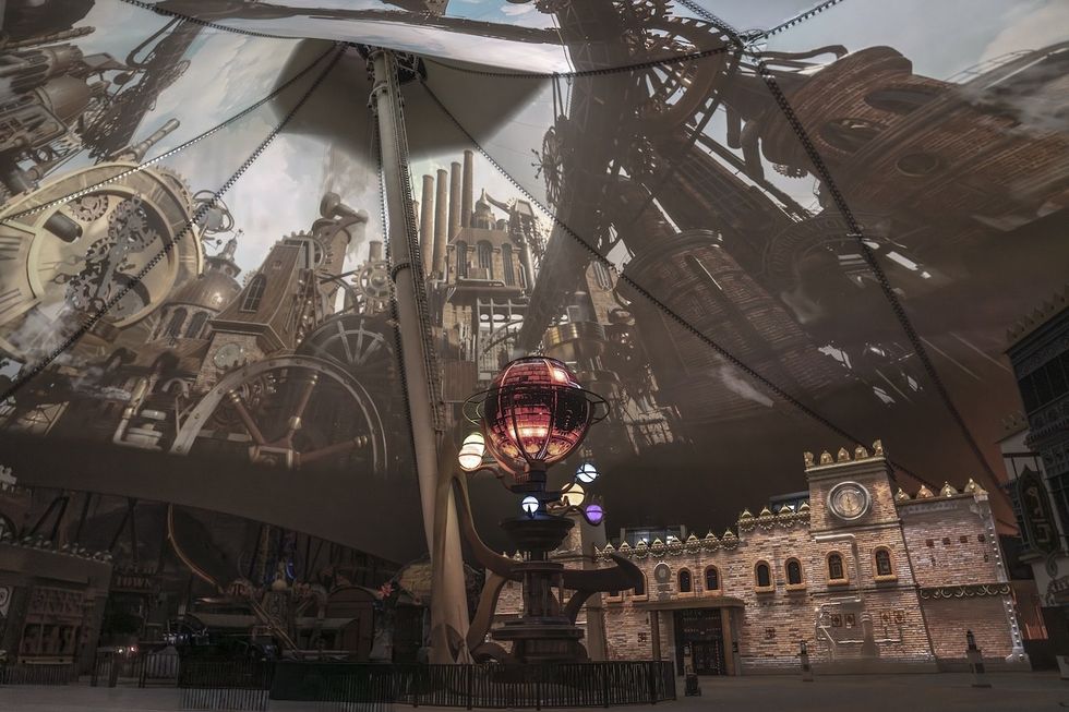 Steampunk cityscape with intricate machinery and a large brass structure under a tented ceiling.