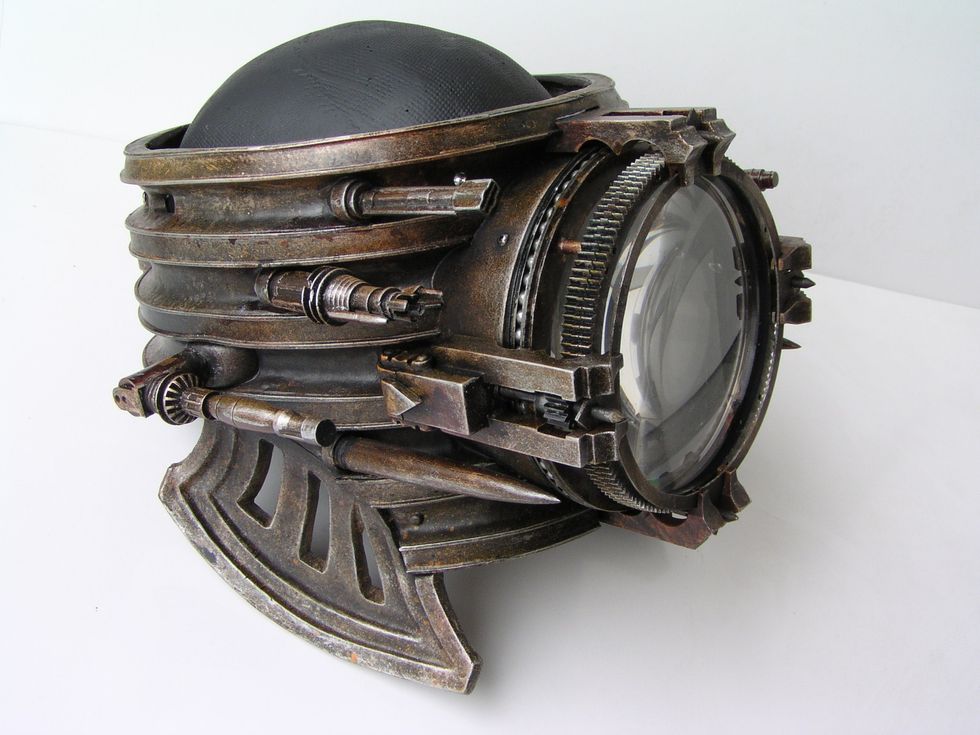 Steampunk-inspired helmet with gears and a large glass lens.