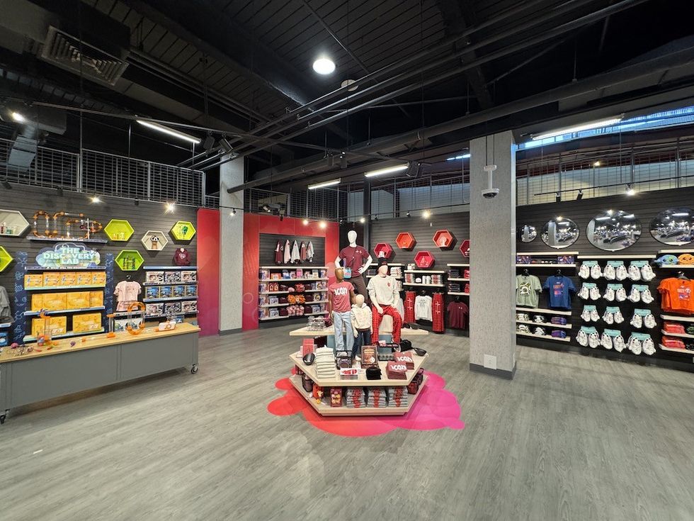 Store interior with colorful wall displays, merchandise, and mannequins dressed in casual wear.