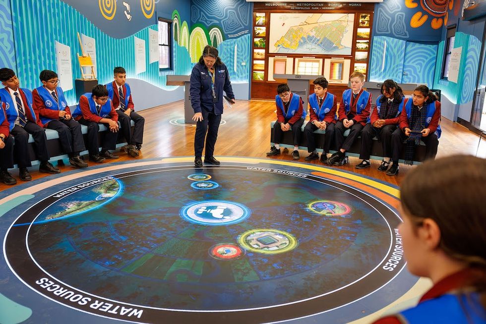 Students in uniforms learning about water sources in an interactive room, Future Water Story by S1T2