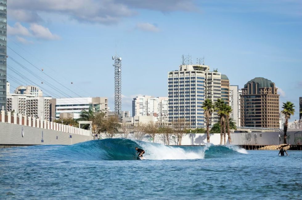 Surfer on a Perfectswell wave in a city
