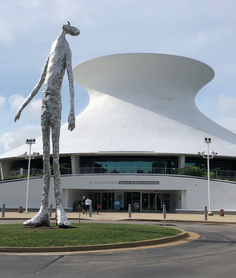 Tall metallic sculpture outside a modern white planetarium building, the James S. McDonnell Planetarium in St. Louis