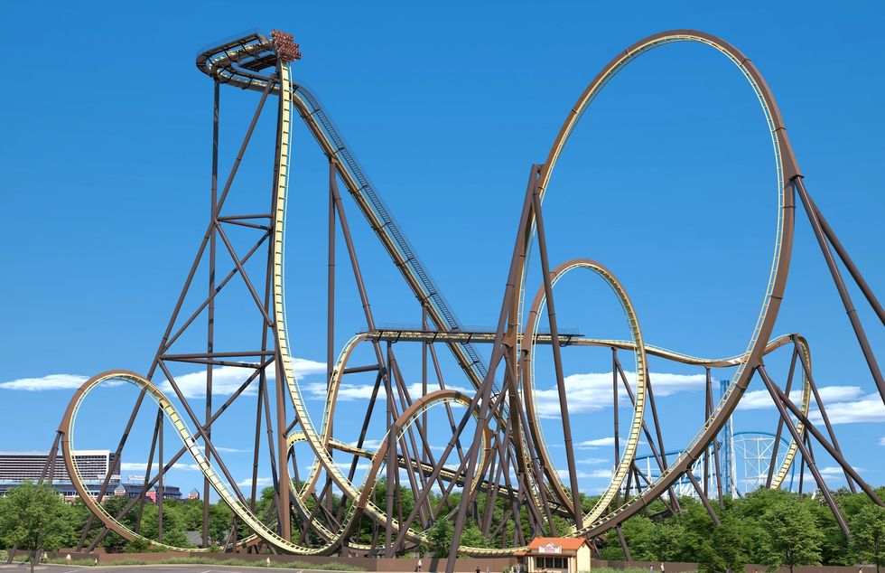 Tall roller coaster with loops against a clear blue sky.