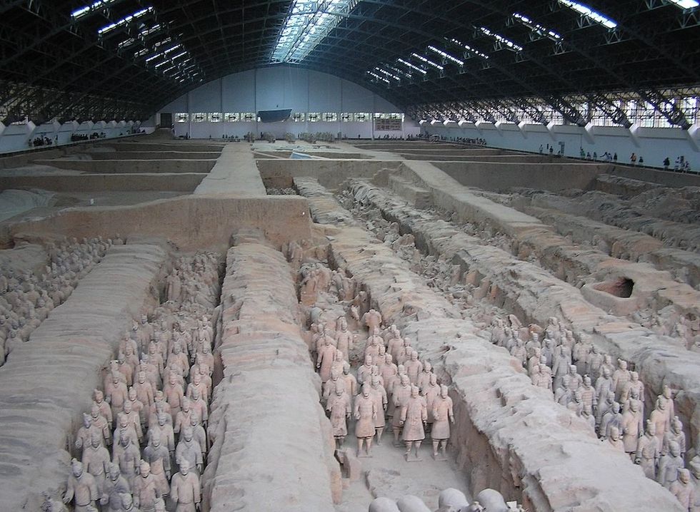 Terracotta Army in a large museum hangar with rows of excavated warrior statues.