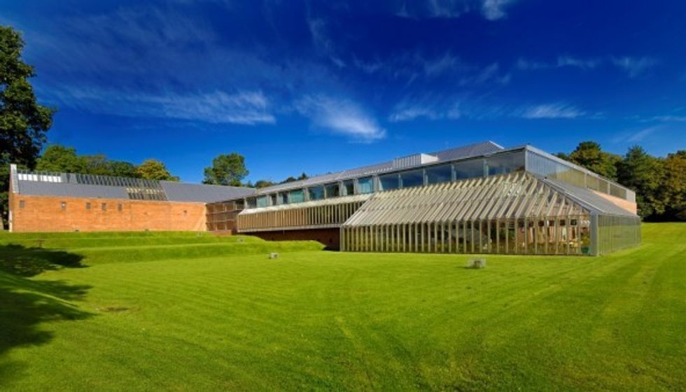 The Burrell Collection, a modern glass-and-brick building on a sunny day with a lush green lawn.