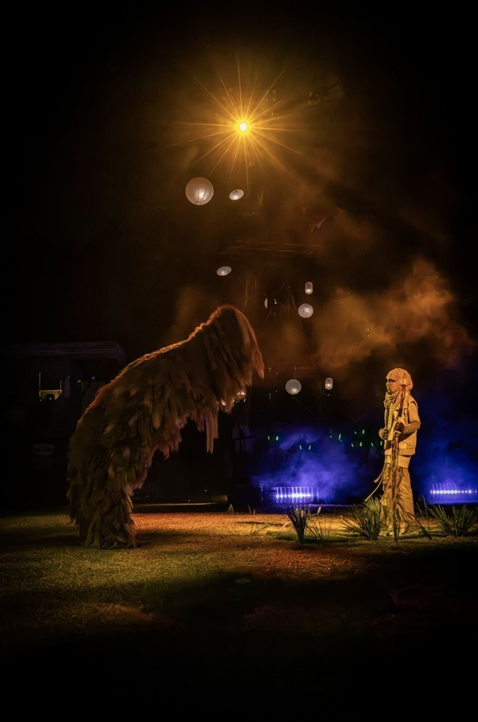 The Cort\u00e8ge: A Festive Funeral for Our Times. A cloaked figure facing a towering creature.