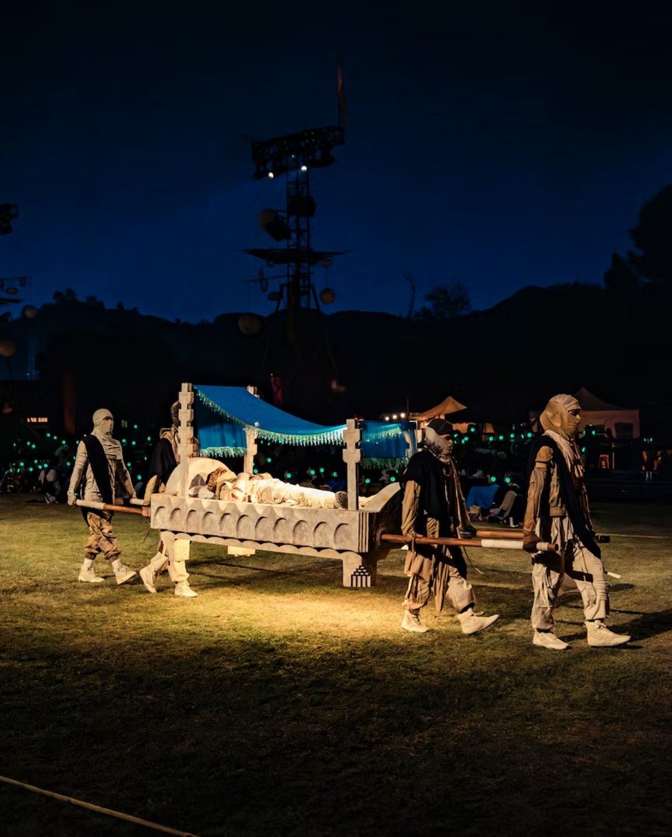 The Cort\u00e8ge: A Festive Funeral for Our Times People in costumes carry a lit, ornate structure funeral bed.