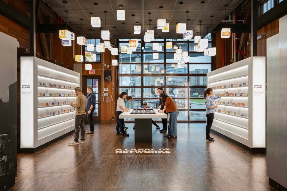 The Erie Canal Bicentennial Experience illuminated shelves and hanging art cubes above.