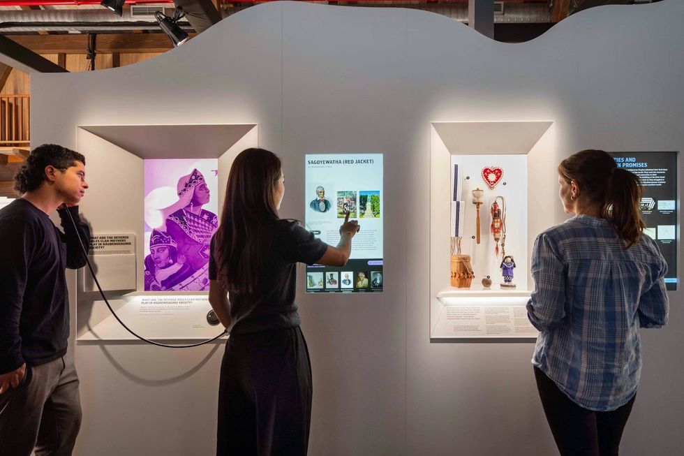 The Erie Canal Bicentennial Experience Visitors engaging with interactive exhibits in a museum display.