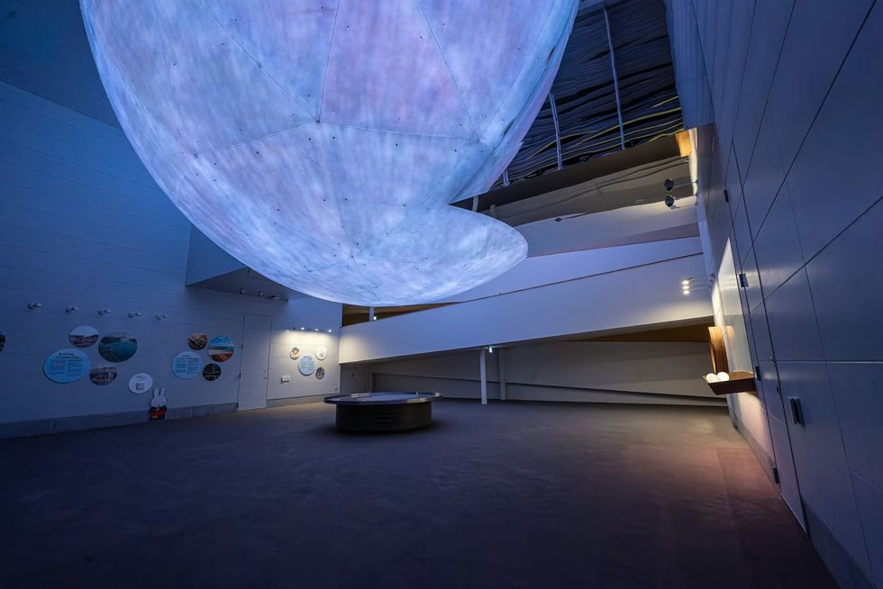 The Netherlands Pavilion at Expo 2025 Futuristic room with large glowing sphere and circular display table.