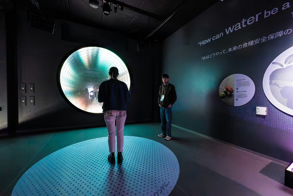 The Netherlands Pavilion at Expo 2025 People in an exhibit room with a glowing circular installation on the wall.