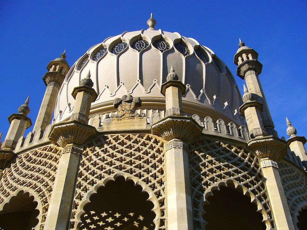 The Royal Pavilion, Brighton, an ornate building with intricate lattice design and dome under a clear blue sky.