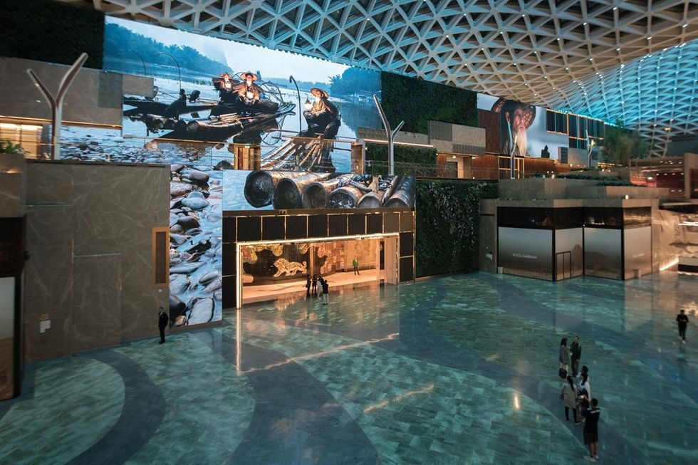 The Spectacle at MGM Cotai, a spacious modern atrium with large digital screens and marble flooring.