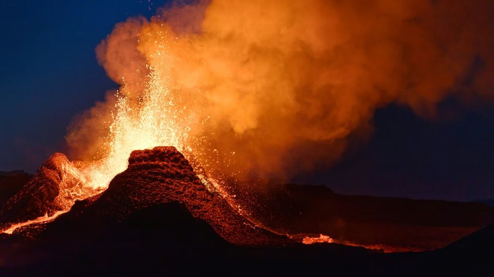 The Volcano Express Erupting volcano with fiery lava and smoke against a dark sky.