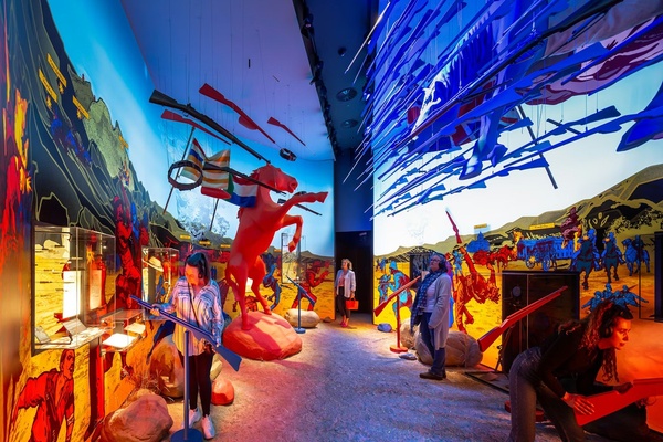 The War Rooms at The Story of Emily. Vibrant interactive exhibit with colorful murals and suspended red and blue elements.