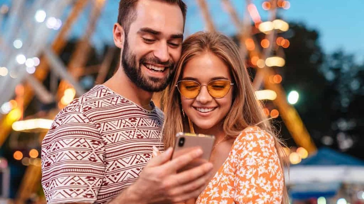 theme park reservations Couple-using-mobile-phone-in-theme-park