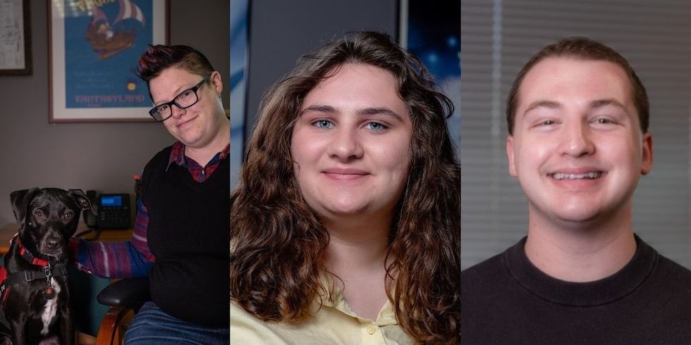 Three individuals smiling indoors, the left person with a black dog.