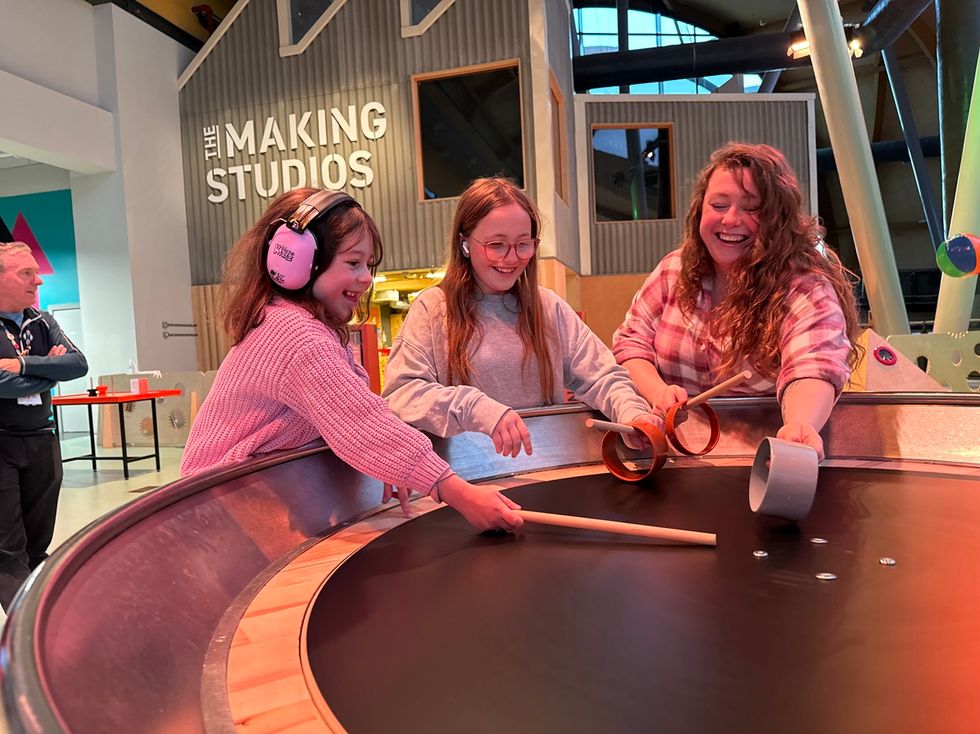 Three people enjoy an interactive exhibit at Life's Making Studios.