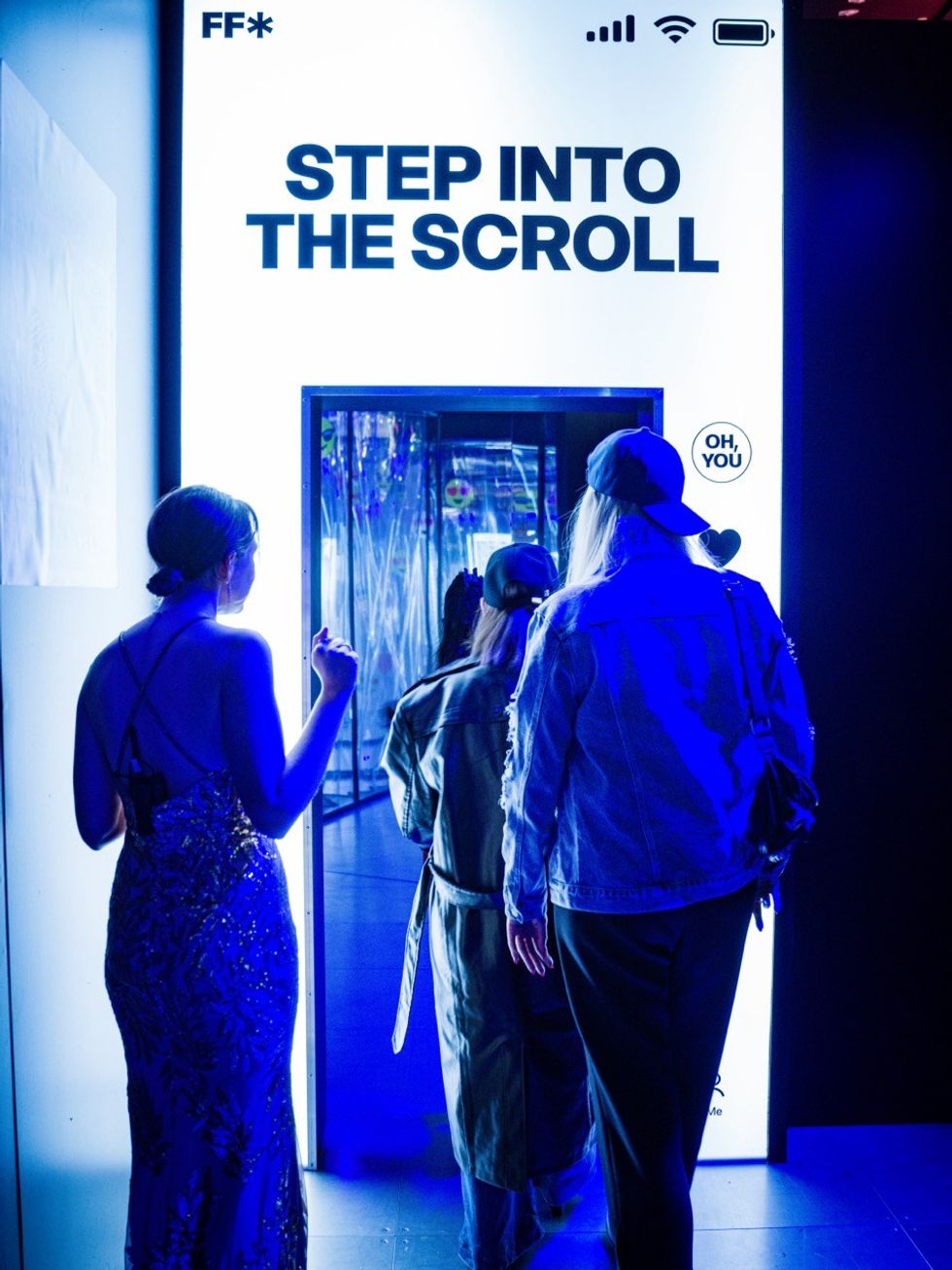Three people entering a glowing portal labeled "STEP INTO THE SCROLL" in blue lighting.