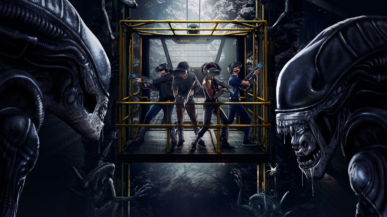 Three people in VR gear, holding guns, surrounded by alien creatures in a dark, industrial setting.
