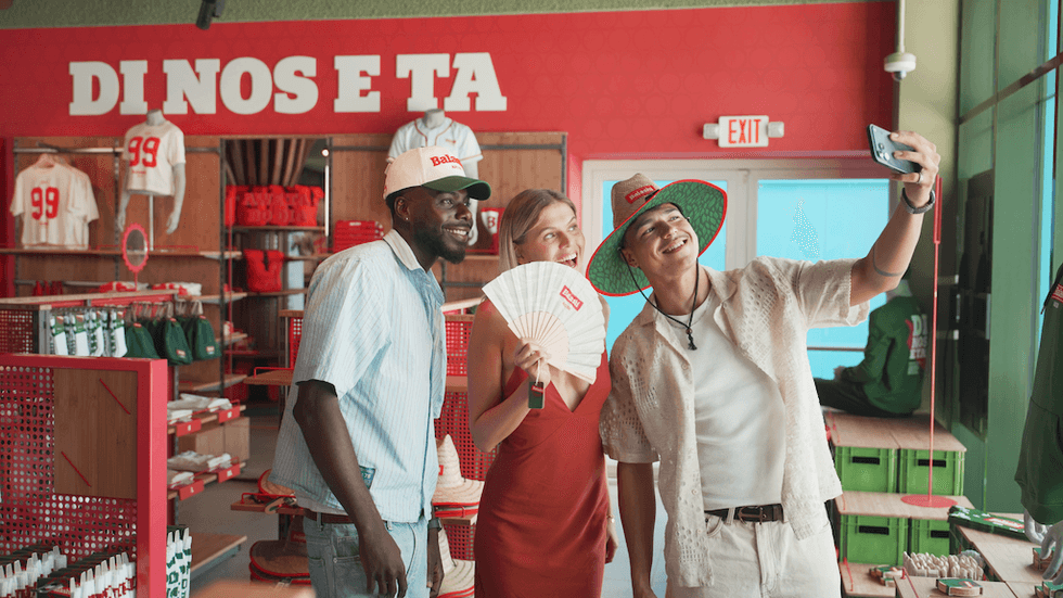 Three people taking a selfie in a retail store with fan merchandise.