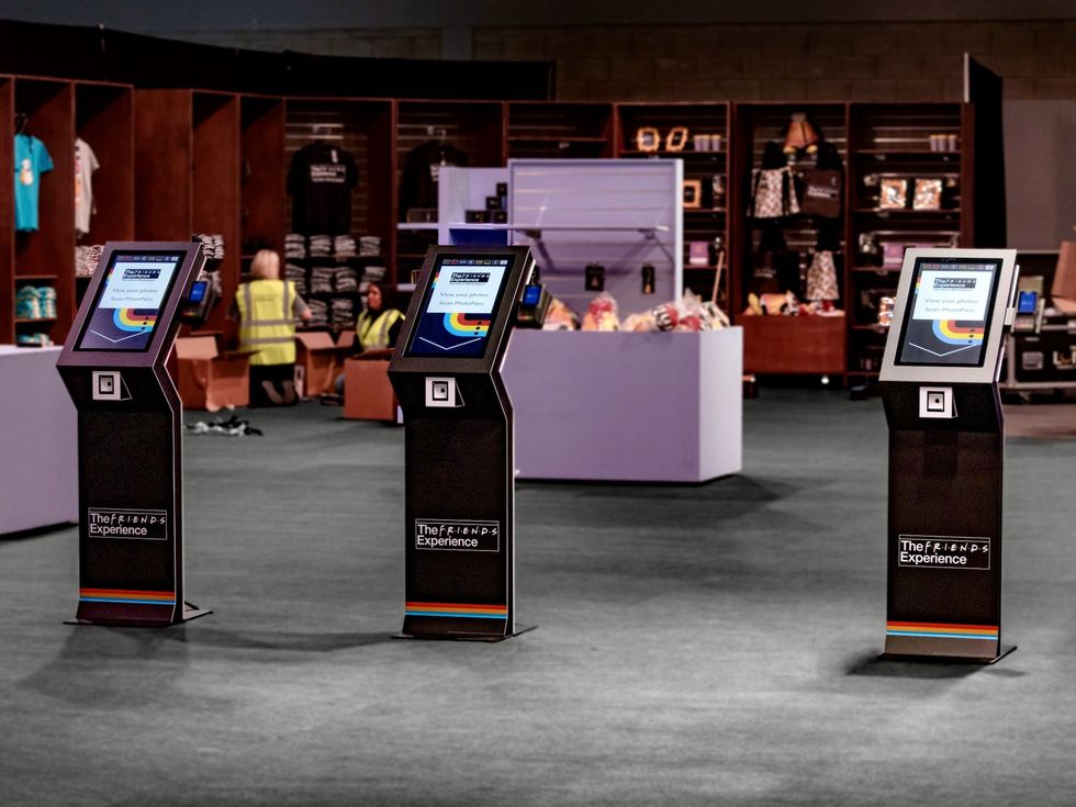 Three photo kiosks at The Friends Experience merchandise area.