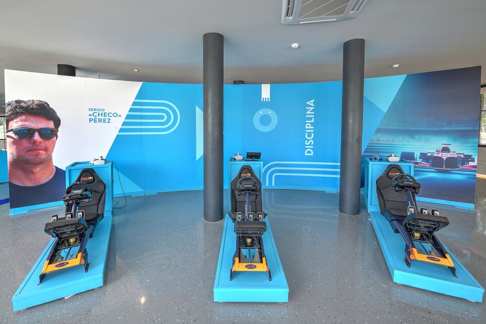 Three racing simulators in a blue-themed room with "Disciplina" on the wall.