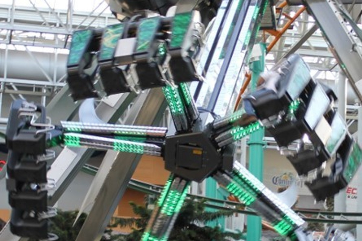 Thrilling indoor amusement ride with rotating, illuminated green arms.