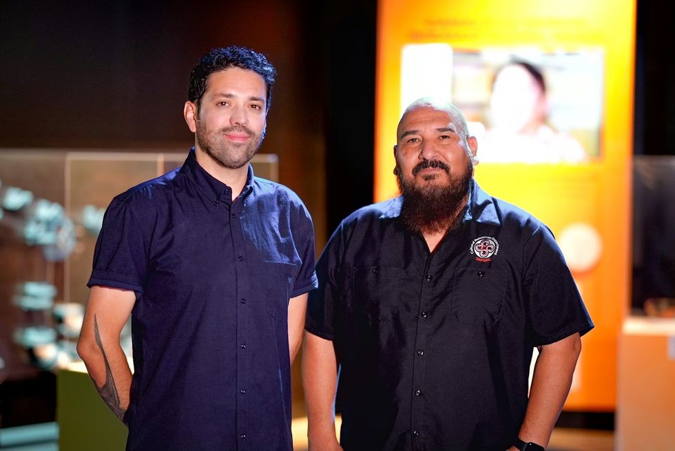 THRIVE \u2014 The First People: Yesterday, Today, and Forever. Two men in dark shirts standing in a dimly lit room with an orange background.