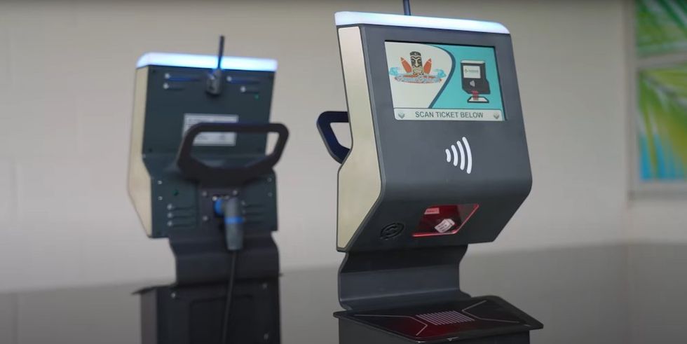 Ticket scanning kiosk with digital screen and barcode reader slot.