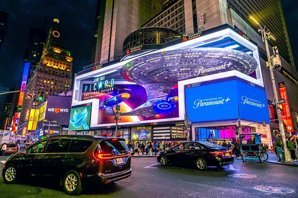 Times Square at night with vibrant digital ads and bustling street traffic.