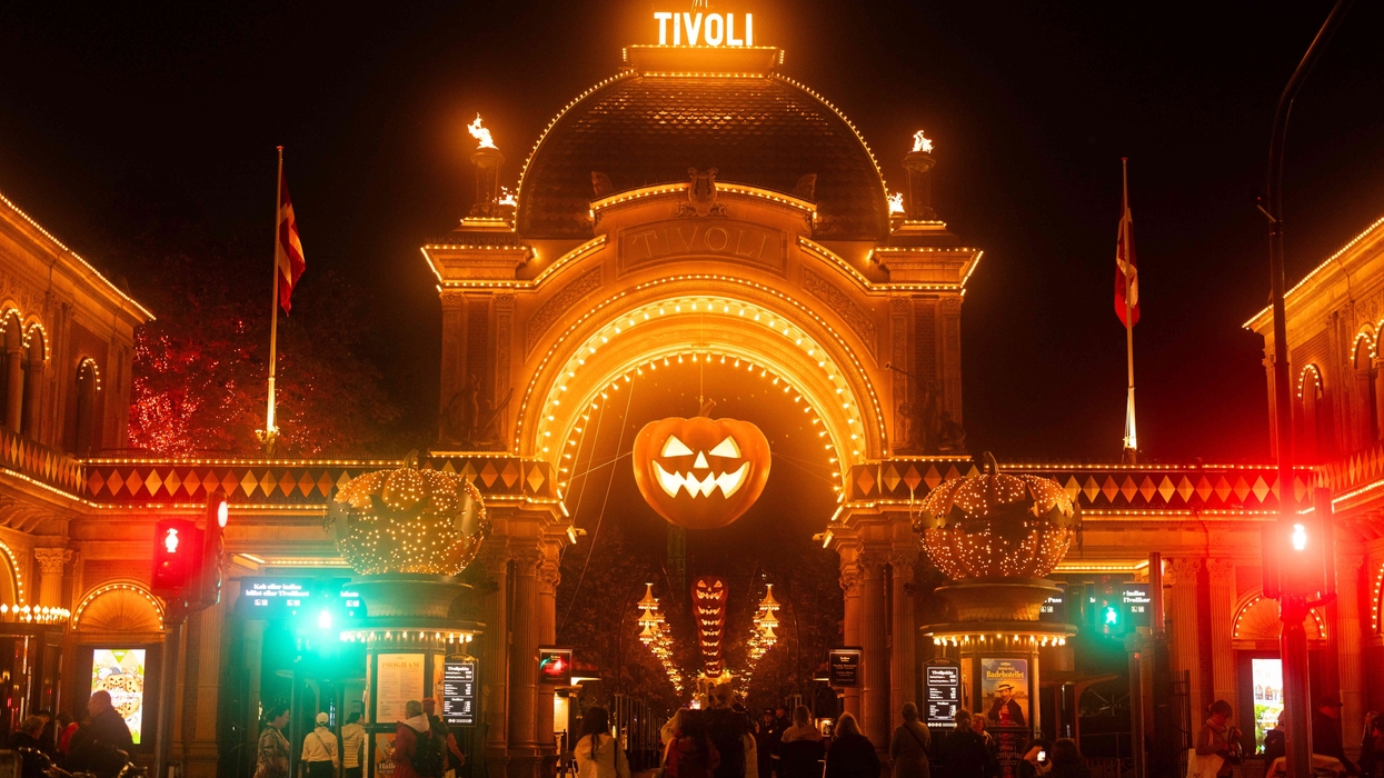 Tivoli Gardens entrance lit up for Halloween with glowing pumpkin decorations at night