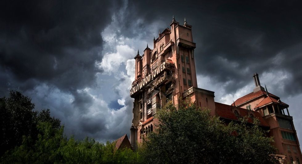 Towering building under dark, stormy clouds, with "Hollywood Tower Hotel" sign.