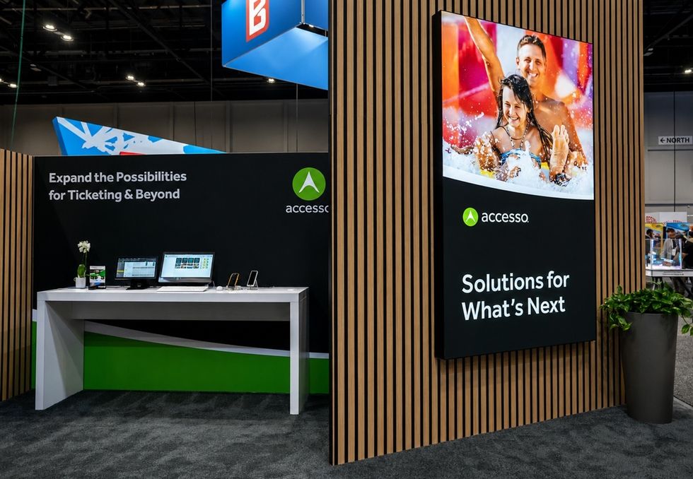 Trade show booth with accesso branding and digital displays.