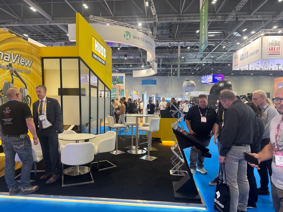 Trade show booth with people interacting and a variety of colorful displays.
