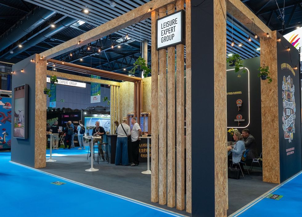 Trade show booth with wooden frame and people interacting.