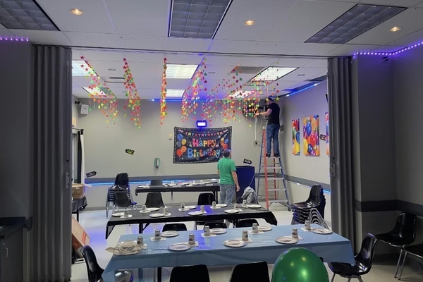 TwinkleTwinkleStar Room decorated for a birthday party with people hanging star streamers.