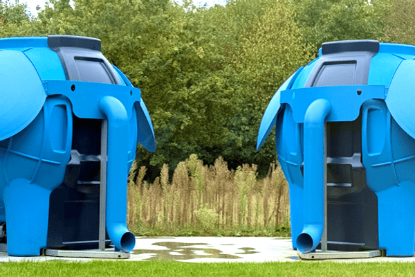 Two blue elephant-shaped structures in a grassy area.