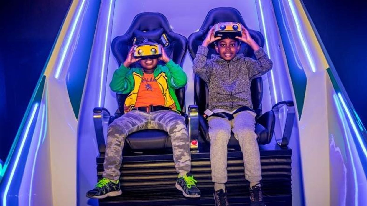 two boys wearing headsets sit in immotion vr pod at legoland discovery center boston usa