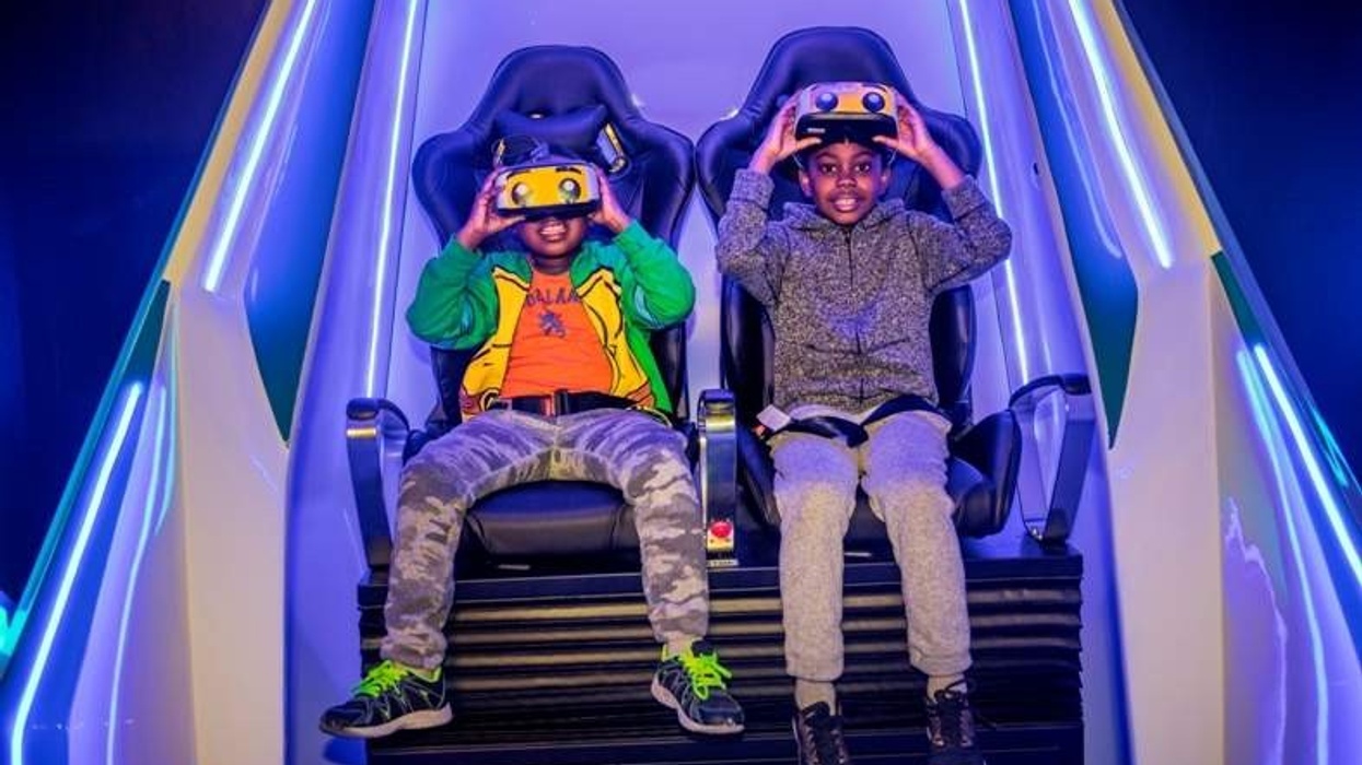 two boys wearing headsets sit in immotion vr pod at legoland discovery center boston usa