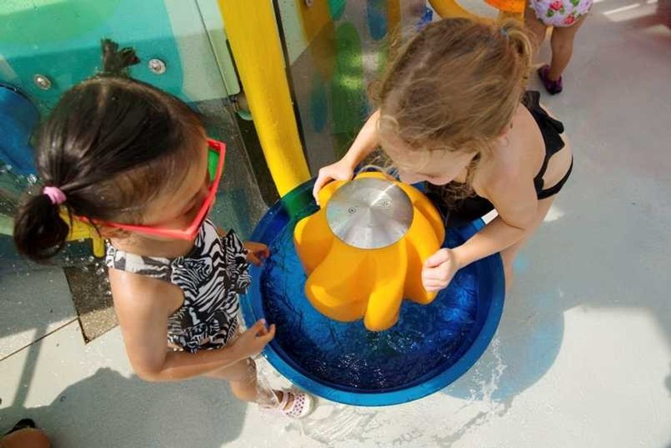 two girls play with playnuk aquatic play structure