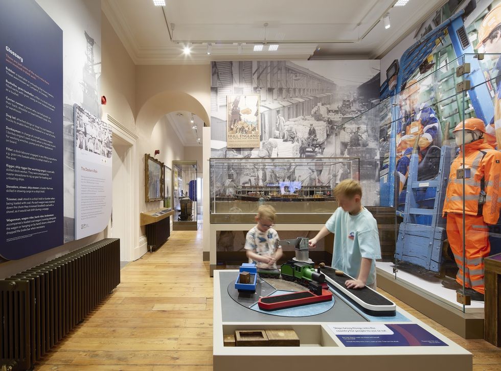 Two kids playing with an interactive display at a maritime museum exhibit.