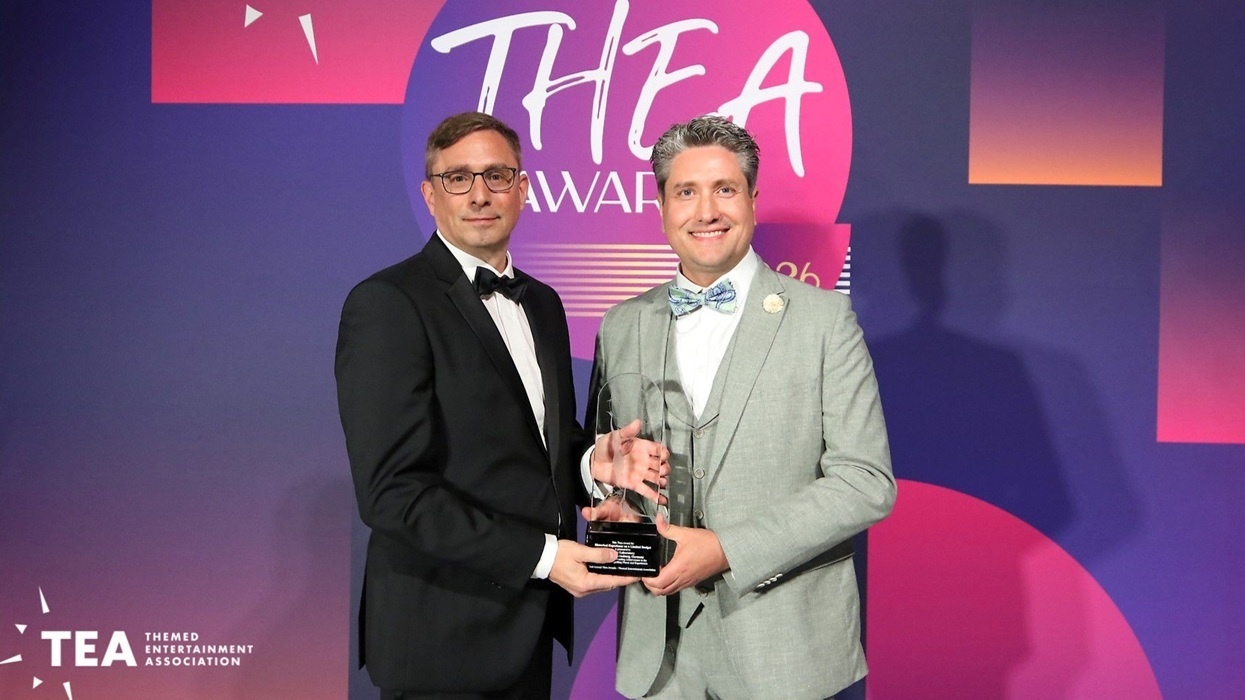 Two men holding an award at the TEA Thea Awards ceremony.