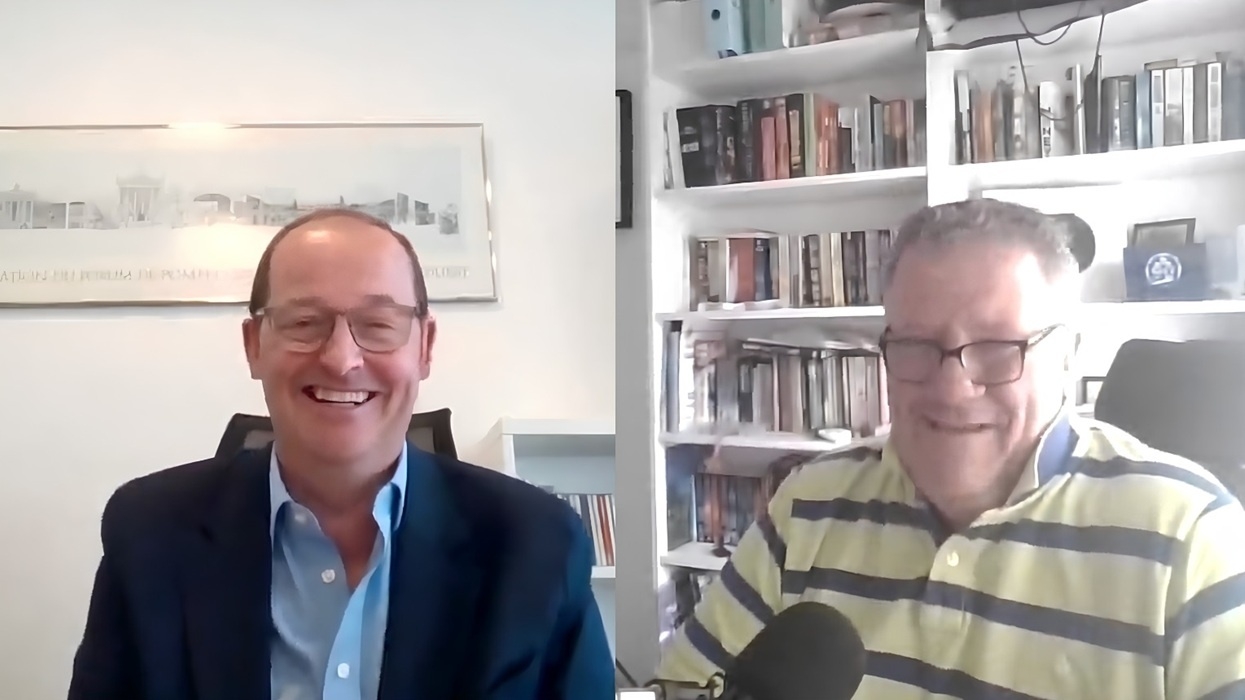 Two men, named Duncan Phillips and Andy Povey, smiling during a video call, bookshelf in the background.