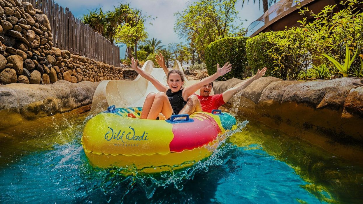 Two people in a colorful raft enjoying a water slide at Wild Wadi Waterpark.