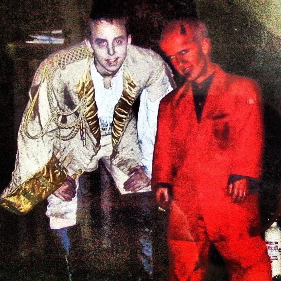 Two people in spooky costumes, one in regal attire and the other in red with horns.